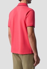 Polo shirt da uomo a maniche corte, rosa vivace, cotone texturizzato, colletto e orlo scuri a contrasto, spacchetti laterali sul fondo.