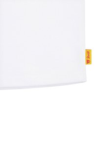 Tessuto bianco con superficie testurizzata, caratterizzato da un piccolo etichetta gialla con un emblema sul lato destro.