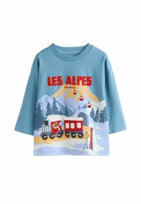 Jasnoniebieska koszulka z krótkim rękawem z kolorową grafiką pociągu górskiego, napisem "LES ALPES" oraz ilustracjami akcesoriów narciarskich na dolnej krawędzi.