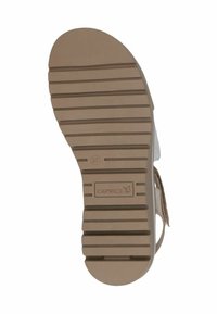 Brun gummisula med en texturerad design, som har horisontella spår. Präglat logotyp "CAPRICE" nära hälen och storleksindikation "37."