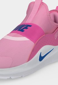 Ροζ sneaker Nike slip-on με ελαστικό λουράκι στο πάνω μέρος, μπλε λογότυπο swoosh σε λευκή σόλα και το κείμενο «Just Do It» στο πλάι.