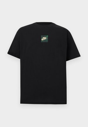 Čierne tričko s krátkym rukávom s malým zeleným a béžovým štvorcovým logom Nike umiestneným v strede na hrudi na bielom pozadí.