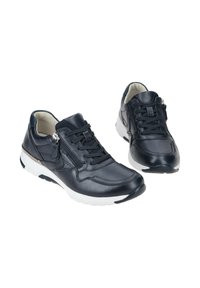 Zapatillas de cuero azul marino con superficie texturizada, que cuentan con una suela de goma blanca, cordones y un cierre de cremallera adicional en el lateral.
