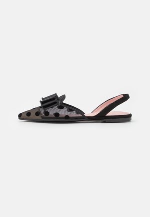 Zapato plano slingback negro con tejido transparente de lunares y un gran lazo de tela en la punta puntiaguda.