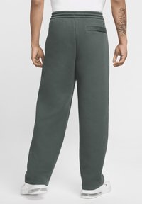 Σκούρο πράσινο παντελόνι φόρμας με άνετη εφαρμογή, ελαστική μέση και μία πίσω τσέπη, φτιαγμένο από μαλακό, υφασμάτινο ύφασμα.