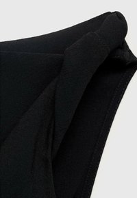 Tissu noir avec une finition douce et texturée, présentant des bords incurvés et des détails de couture. Le matériau est léger et élastique.