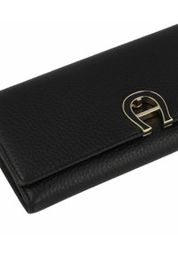 Zwarte leren portemonnee met een getextureerd oppervlak. Voorzien van een gouden metalen sluiting in de vorm van een "A" aan de voorkant. Compact ontwerp.