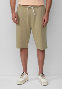 Beige Baumwollshorts mit einem elastischen Bund und weißem Kordelzug, ausgestattet mit Seitentaschen und einer leicht strukturierten Oberfläche.
