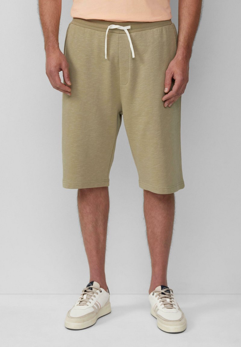 Beige Baumwollshorts mit einem elastischen Bund und weißem Kordelzug, ausgestattet mit Seitentaschen und einer leicht strukturierten Oberfläche.
