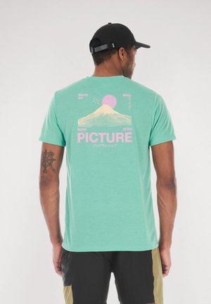 Mint green short-sleeve t-shirt featuring a mountain graphic and text in pink and white on the back. Soft fabric with a relaxed fit.