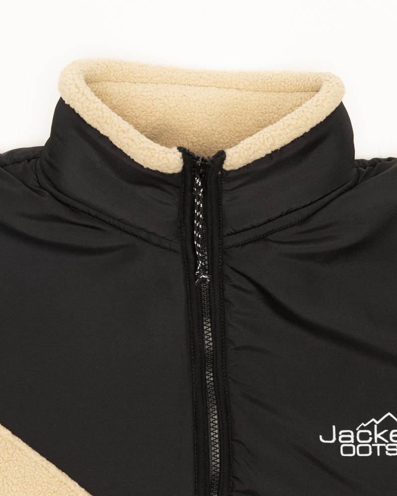 Veste noire avec un col haut, ornée d'une finition en polaire beige et d'un zip central. Le tissu semble lisse avec un léger éclat.