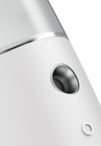 Enceinte blanche au design arrondi, avec un dessus métallique et un bouton de contrôle circulaire. Présente une grille d'enceinte dans le port latéral.