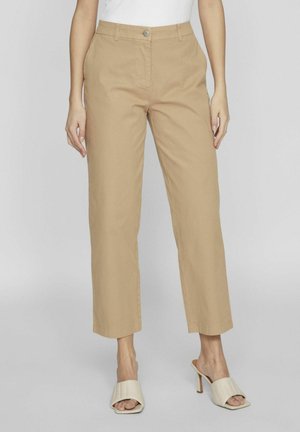Pantalones recortados beige con un diseño de pierna recta, fabricados en algodón. Cuentan con un cierre de botón y bolsillos laterales. Tejido texturizado.