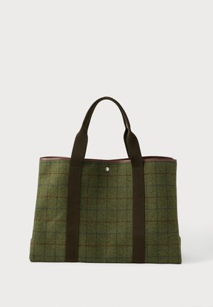 Žalia vilnos krepšys su rudu tinklo raštu, tamsiai rudos spalvos rankenos ir vienas sidabrinis mygtuko užsegimas viršuje centre.