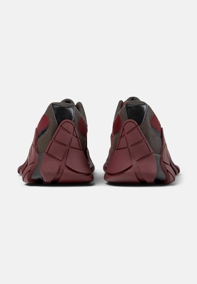 Paar dunkelroter und grauer Sneaker, von hinten gezeigt, mit dicken, gerillten Sohlen und Einsätzen aus Mesh-Gewebe.