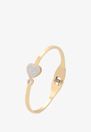 Guldring med en hjerteformet charm besat med små krystaller og en enkelt rund krystal på en slank ring med en lås.