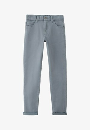 Sive traperice uskog kroja s podvrnutim rubovima, prednjim gumbom, patentnim zatvaračem i dizajnom s pet džepova.