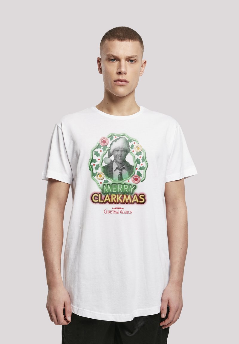 Hvit bomulls T-skjorte med et fargerikt grafisk trykk med julestemning, inkludert teksten "Merry Clarkmas" og et design av en misteltein.