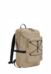 Sac à dos rectangulaire beige avec poche zippée à l'avant, cordons élastiques noirs, bretelles rembourrées, et logo empreinte de patte noire en bas à l'avant.