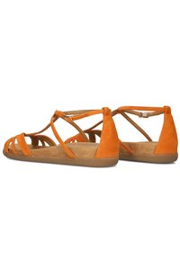 Suède oranje sandalen met meerdere kruislings geplaatste banden en een platte, bruine rubberen zool. Voorzien van een gespsluiting op de enkelband.