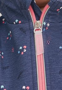 Marineblaue Zip-Hoodie mit kleinen Blumenmustern in Pink und Hellblau. Verfügt über einen pinken Reißverschluss und eine strukturierte Stoffoberfläche.
