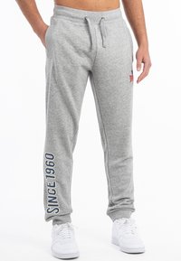 Grå sweatpants lavet af blød bomuldsblanding, med snor i taljen, sidelommer og hvid tekst "SINCE 1960" på venstre ben.