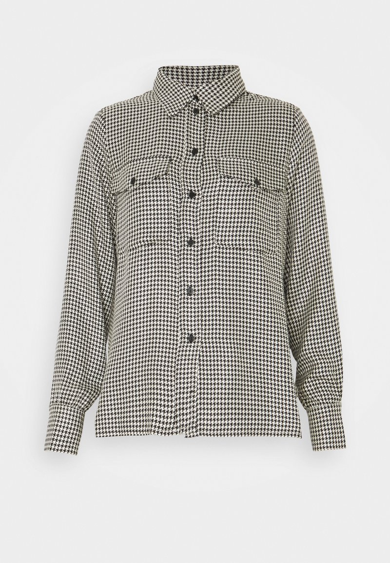 Chemise à carreaux pied-de-poule noir et blanc, boutonnée, manches longues, col et deux poches poitrine à rabat avec boutons.