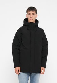 Svart puffjakke med hette, med glidelås foran, snor detaljer og en avslappet passform. Smooth tekstur, minimalistisk design.