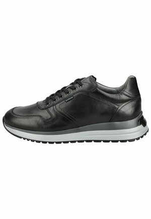 Zwarte leren sneaker met veters, witte zool en gestructureerde rubberen onderkant, met zicht op de buitenkant van de rechter schoen.