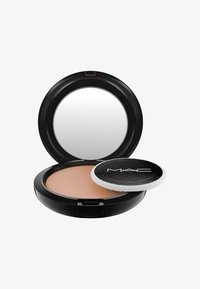 MAC pressed poeder compact met een zwarte behuizing. Voorzien van een ronde spiegel en een beige poeder aan de binnenkant, vergezeld door een witte applicator puff.