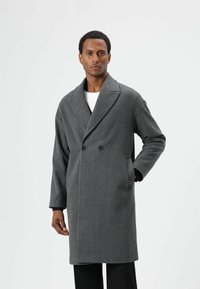 Grijs double-breasted jas met een getailleerde pasvorm, voorzien van een brede revers, zijzakken en een gladde wollen textuur.