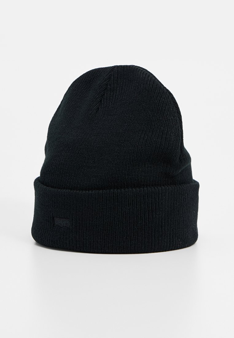 Bonnet en tricot noir avec une texture côtelée, revers replié et une marque discrète fixée sur le côté. Il présente un design classique et simple.