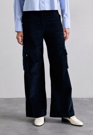 Spodnie cargo o szerokich nogawkach w ciemnonawowym kolorze, z bocznymi kieszeniami, lekko teksturowanym wykończeniem i luźnym krojem.