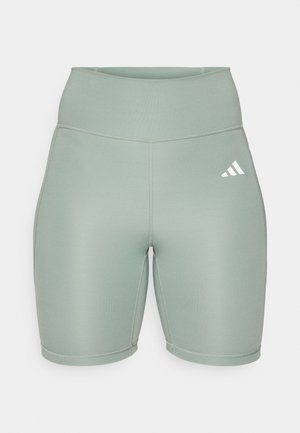 Gai zaļi sporta šorti ar augstu vidukli, izgatavoti no elastīga auduma, ar plakanām šuvēm un balto logotipu kreisajā pusē.