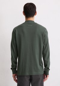 Dunkelgrün, langärmeliges Baumwollhemd mit Rundhalsausschnitt und gerippten Bündchen, das eine einfache, glatte Textur und ein minimalistisches Design aufweist.