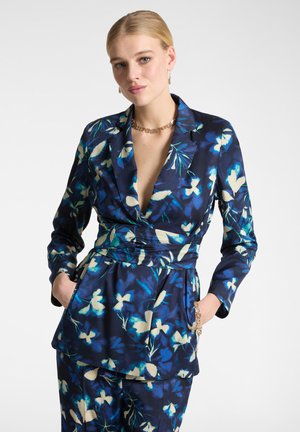 Blazer a fantasia floreale in blu navy, con fiori bianchi e blu, vestibilità sartoriale, maniche lunghe, scollo a V e vita cinchata con tasca.