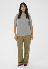 Harmaa neulepaita, jossa on lyhyet, puffi hihat; oliivinvihreät leveälahkeiset housut; maroonit kengät; sileä rakenne ja rento istuvuus.