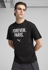 Sort bomulds T-shirt med hvid tekst "FOREVER. PARIS." og et lille hvidt Puma-logo. Korte ærmer og rund hals.