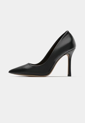 Sorte patentlæder højhælede pumps med spids tå, slank stiletthæl og glat tekstur; minimalistisk design med tan sål.