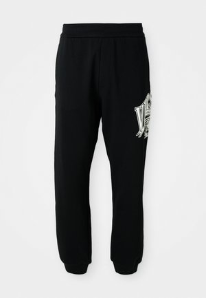 Sorte sweatpants lavet af blødt stof, med en ribbet talje og manchetter. Inkluderer et grafisk print i hvid og grå på venstre ben.