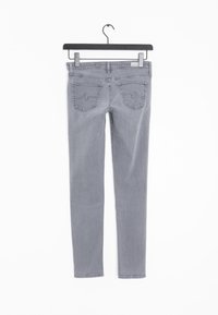 Šedé džíny s úzkým střihem, vybavené dvěma zadními kapsami a poutkem na zavěšení. Materiál má jemnou strukturu a hladký povrch.