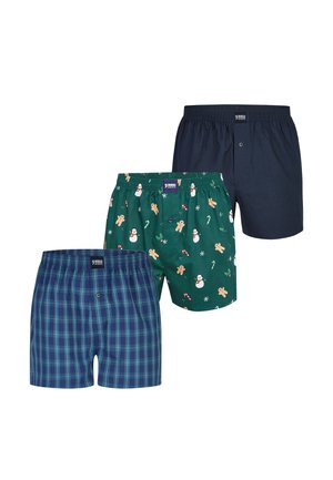 Drie paar herenshorties: één in navy, één groen met vakantiedessins en één blauw met ruitpatroon, elk met een elastische tailleband.