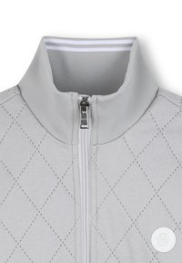 Veste zippée gris clair avec un motif matelassé à surpiqûres en diamant, col blanc contrastant et patch logo à l'avant.