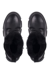 Botas de cuero negro con un forro negro esponjoso y suelas texturizadas. El diseño incluye cordones y costuras prominentes en la parte superior.