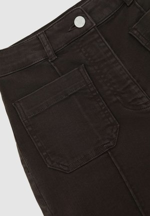 Prim-plan cu pantaloni din denim negru, prezentând un buzunar din spate, o buclă pentru curea și un nasture metalic argintiu pe talie.