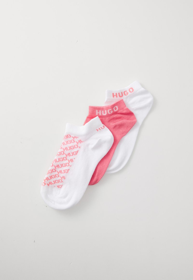 Três pares de meias de cano baixo em branco e rosa. As características incluem o logo "HUGO" em rosa nas meias brancas e texto padronizado nas meias rosas. Material macio.