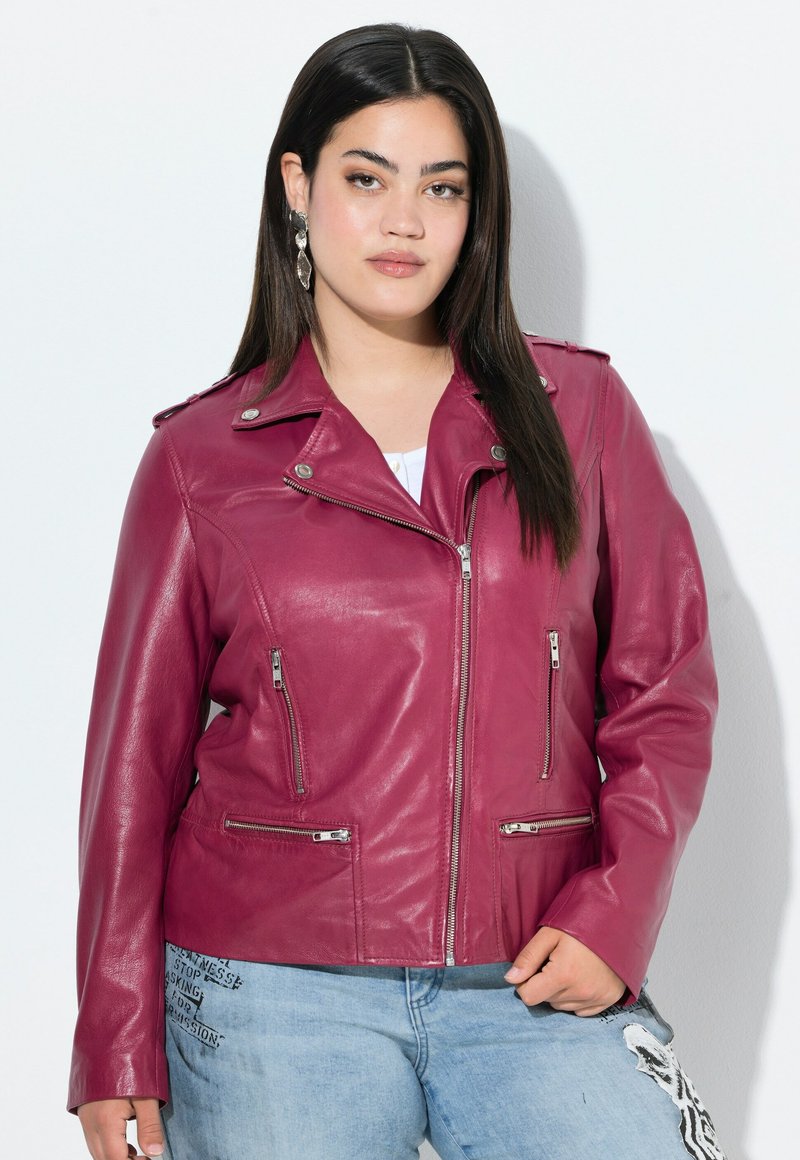 Bordeaux leren jack met ritssluitingzakken, asymmetrische ritssluiting en drukknopdetail op de kraag. G gedragen over denim met grafische accenten.