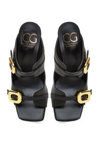 Schwarze Leder-Sandalen mit offenem Zehenbereich in rechteckiger Form, ausgestattet mit einem breiten Riemen und goldenen rechteckigen Schnallen an der Seite. Logo in Gold auf der Innensohle.