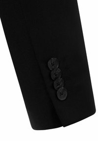 Schwarze maßgeschneiderte Anzugjacke mit einem Ärmel, der vier runde schwarze Knöpfe mit strukturierter Oberfläche und einer Stichnaht in der Nähe des Bündchens aufweist.