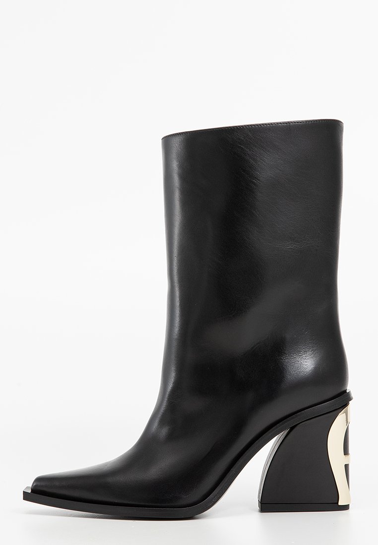Botte noire en cuir, mi-mollet, avec bout pointu et talon bloc courbé unique présentant un effet découpé argenté.